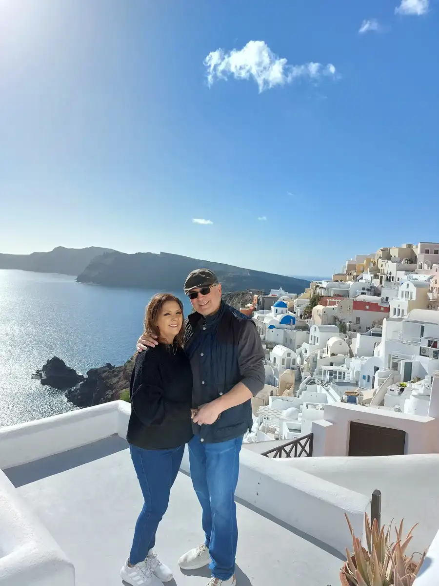 a couple is photographed at the view of Santorini and the sea