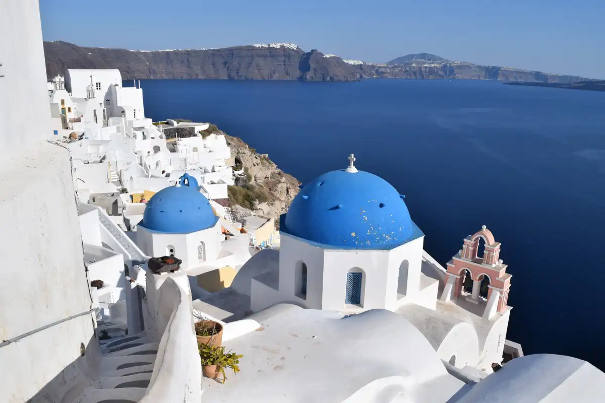 view of a traditional church and white houses in Santorini combined with an amazing sea view