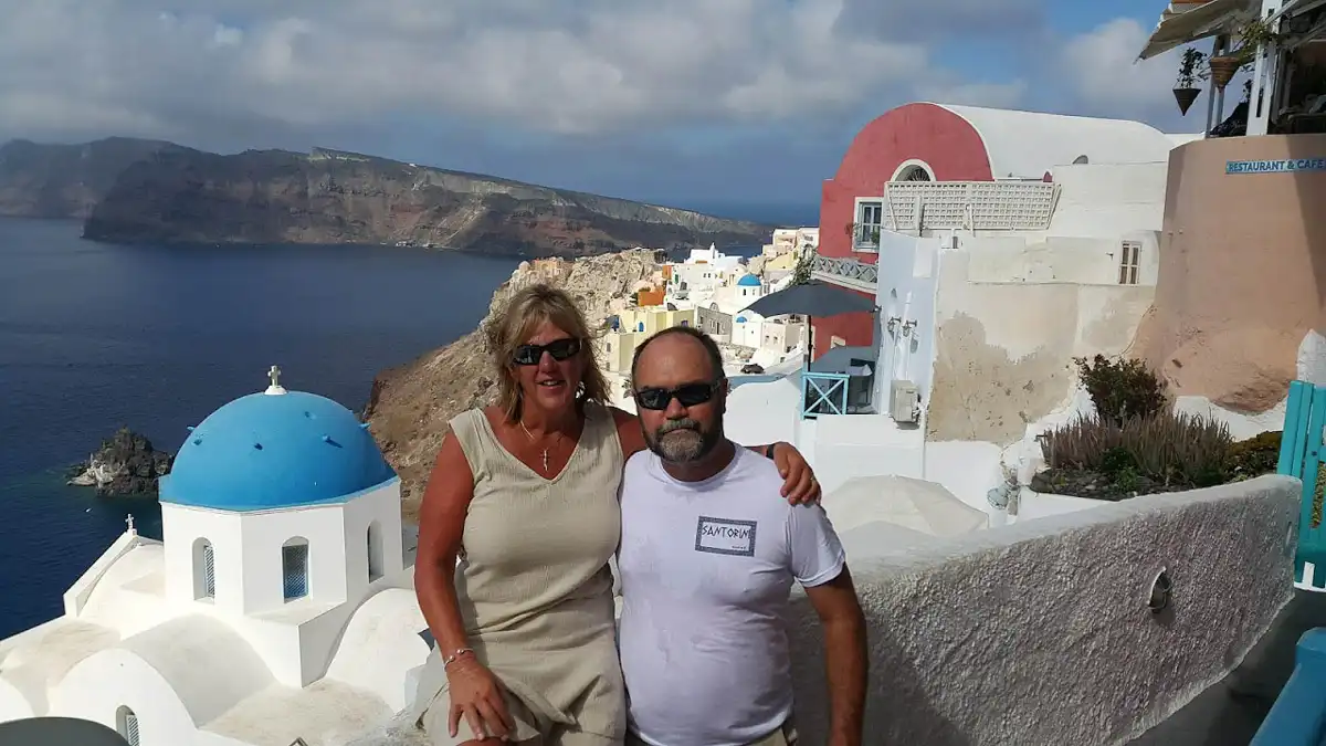couple taking pictures with a view of the amazing santorini