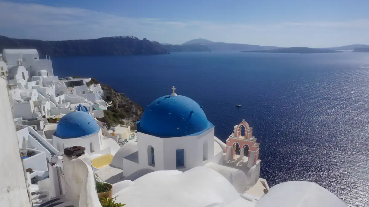 traditional church with blue roof in Santorini and sea view