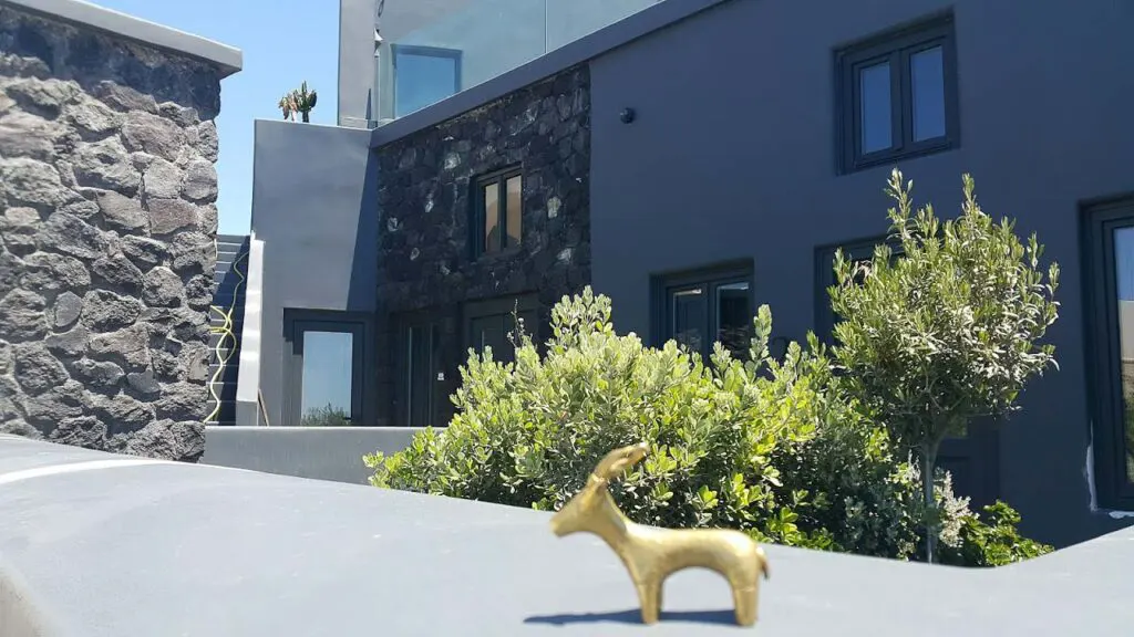 golden ibex statue with a house behind it